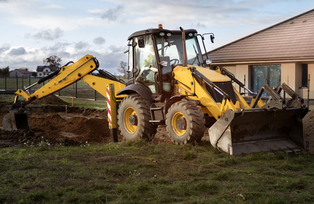 DeBord & Son Construction | digging a hole in a residential yard with a back hoe